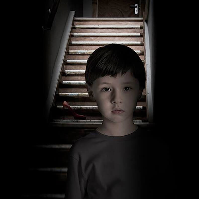 foto van een jonge jongen in een donkere gang die voor een trap staat met een hoge hak op een trede voor het misdaadspel mamma knows best