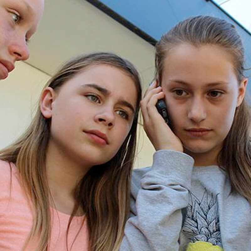 foto van drie meiden die buiten staan en bellen met een geheim agent voor een misdaadspel