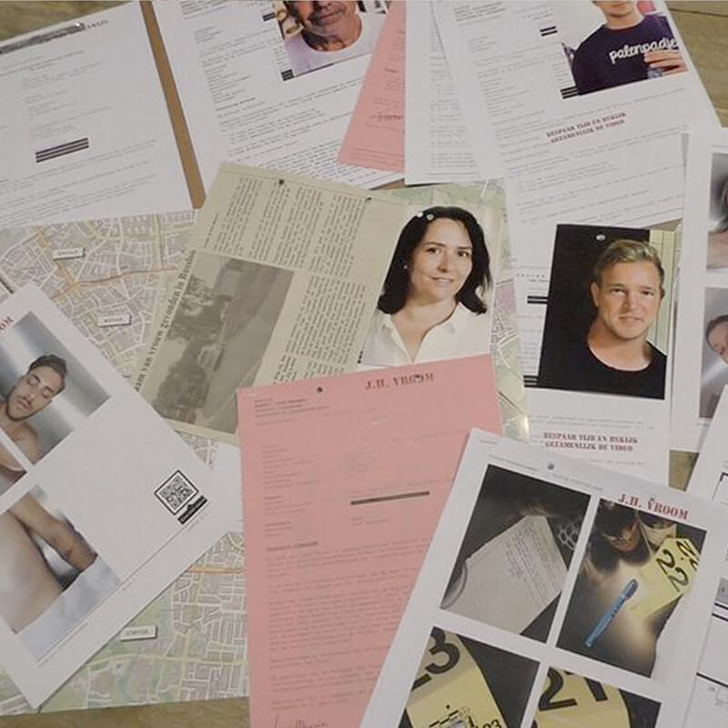 foto van dossiermaterialen uit een politiedossier zoals een krantenartikel, foto's, platteronden en verklaringen voor een moordspel thuis