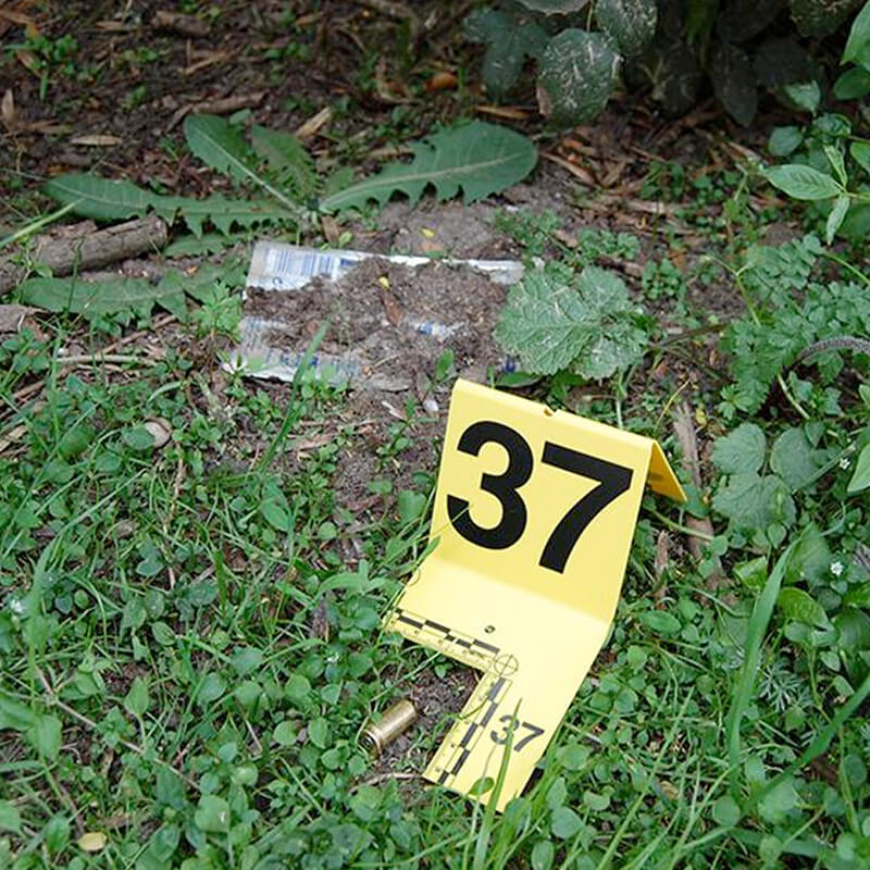 foto buiten van een plaats delict waar een bewijsbordje met nummer 37 naast een kogelhuls is geplaatst voor een misdaadspel